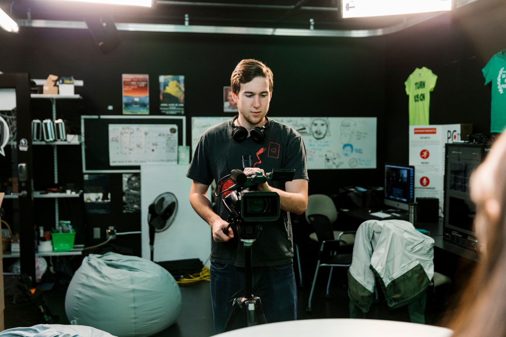 Student using video camera in television studio.