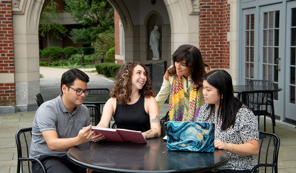 Graduate students with a professor on the Ruane patio
